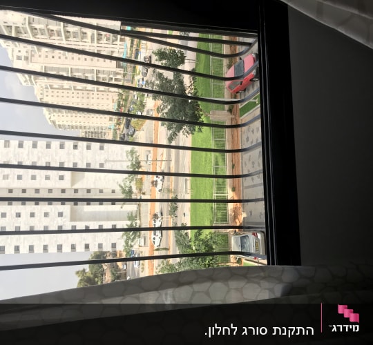 סורגי חלון עם וילון לבן בחלק התחתון